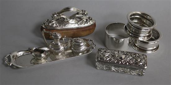 Three single napkin rings, a miniature three piece silver tea set and a tray, an American nail buffer and a toilet jar.